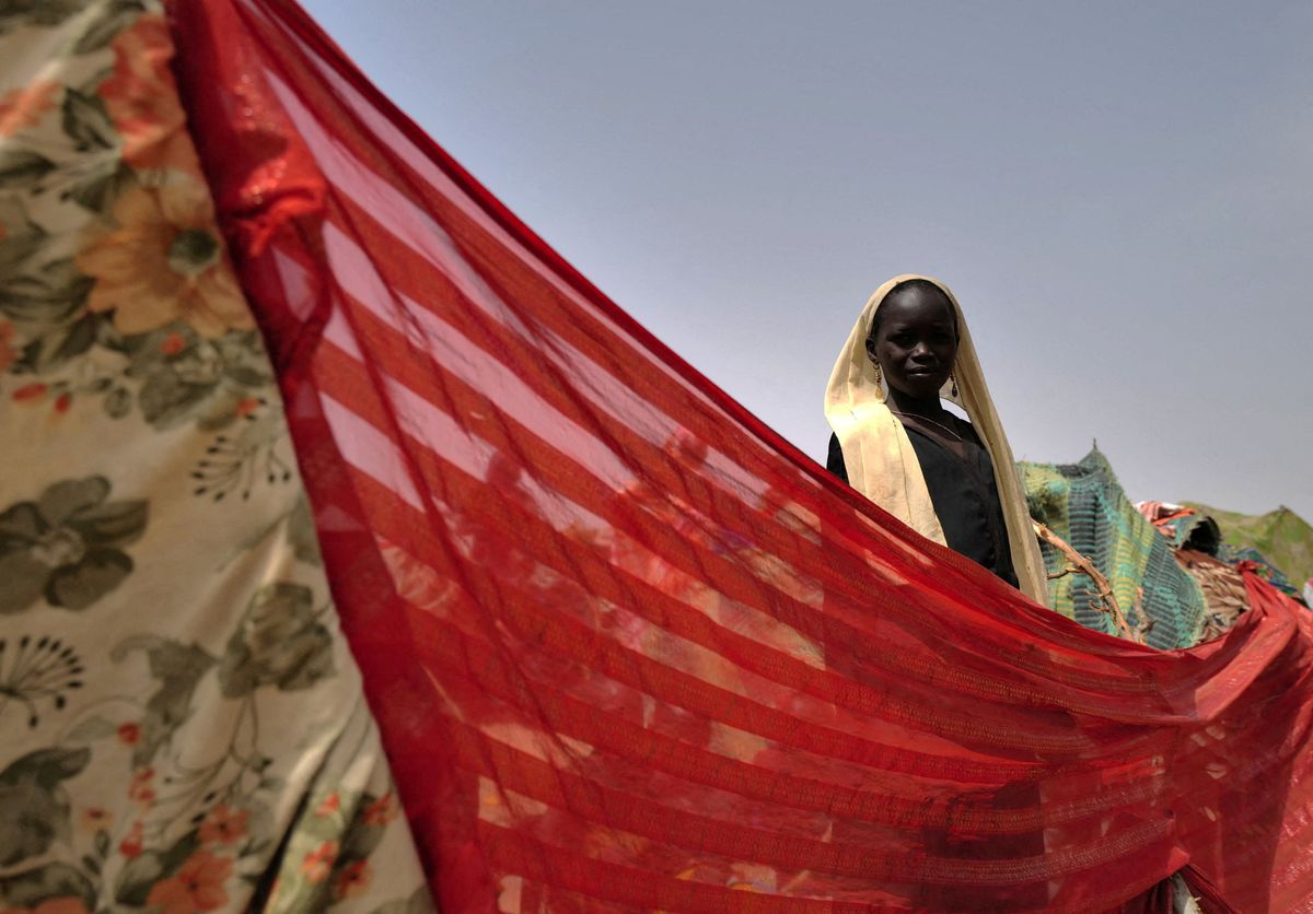 A Sudanese girl who fled the conflict in Darfur stands at her makeshift shelter near the border between Sudan and Chad. 