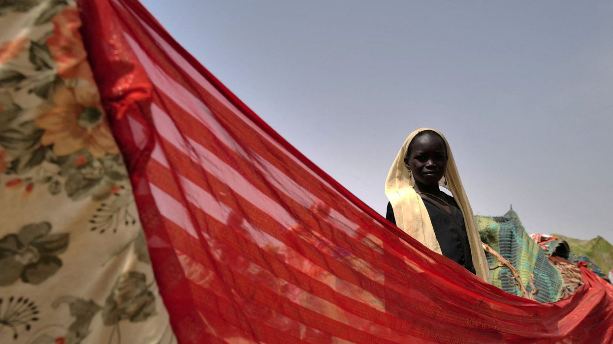 A Sudanese girl who fled the conflict in Darfur stands at her makeshift shelter near the border between Sudan and Chad.