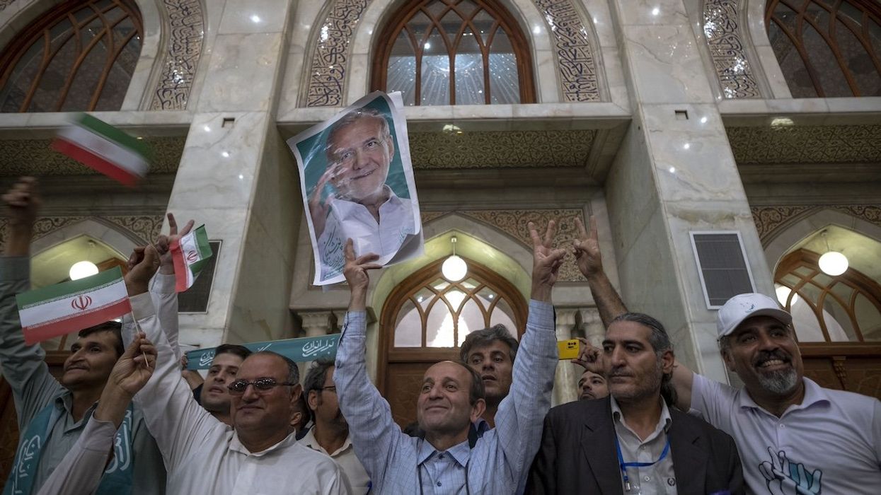 A supporter of Iranian President-elect Masoud Pezeshkian is holding up an electoral poster while participating in a ceremony with Pezeshkian's presence at the Khomeini (Iran's Late Leader) shrine in southern Tehran, Iran, on July 6, 2024. Former reformist Member of Parliament, Masoud Pezeshkian, is being elected as the new President of Iran.