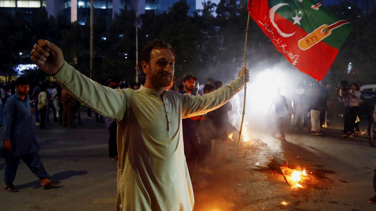 A supporter of Pakistan's former PM Imran Khan in Karachi gestures following the shooting incident on his long march in Wazirabad.