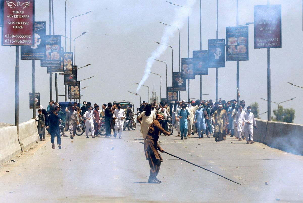 A supporter of Pakistan's former PM Imran Khan throws stones towards police during a protest against Khan's arrest in Peshawar.