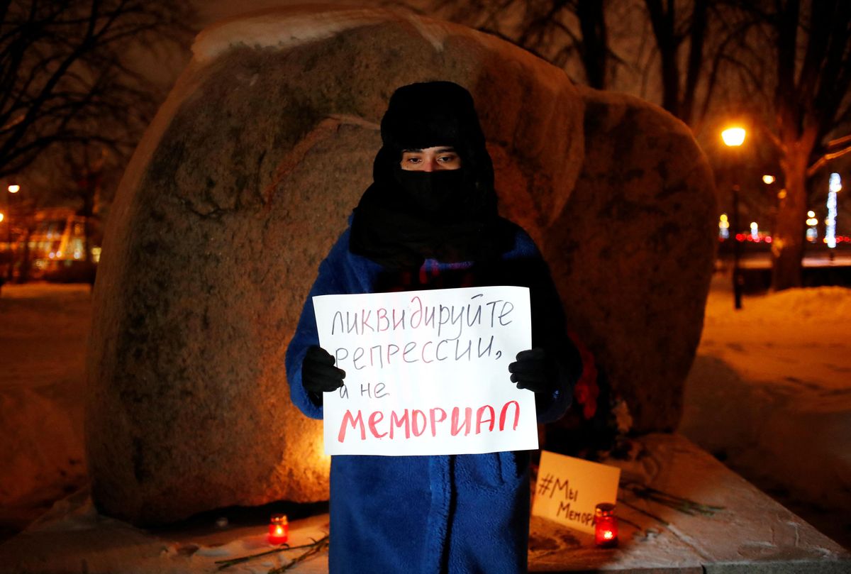 A supporter of the human rights group International Memorial stands with a placard at the Solovetsky Stone memorial after Russia's Supreme Court ruled that International Memorial must be liquidated for breaking the law on foreign agents, in Saint Peterburg, Russia December 28, 2021.