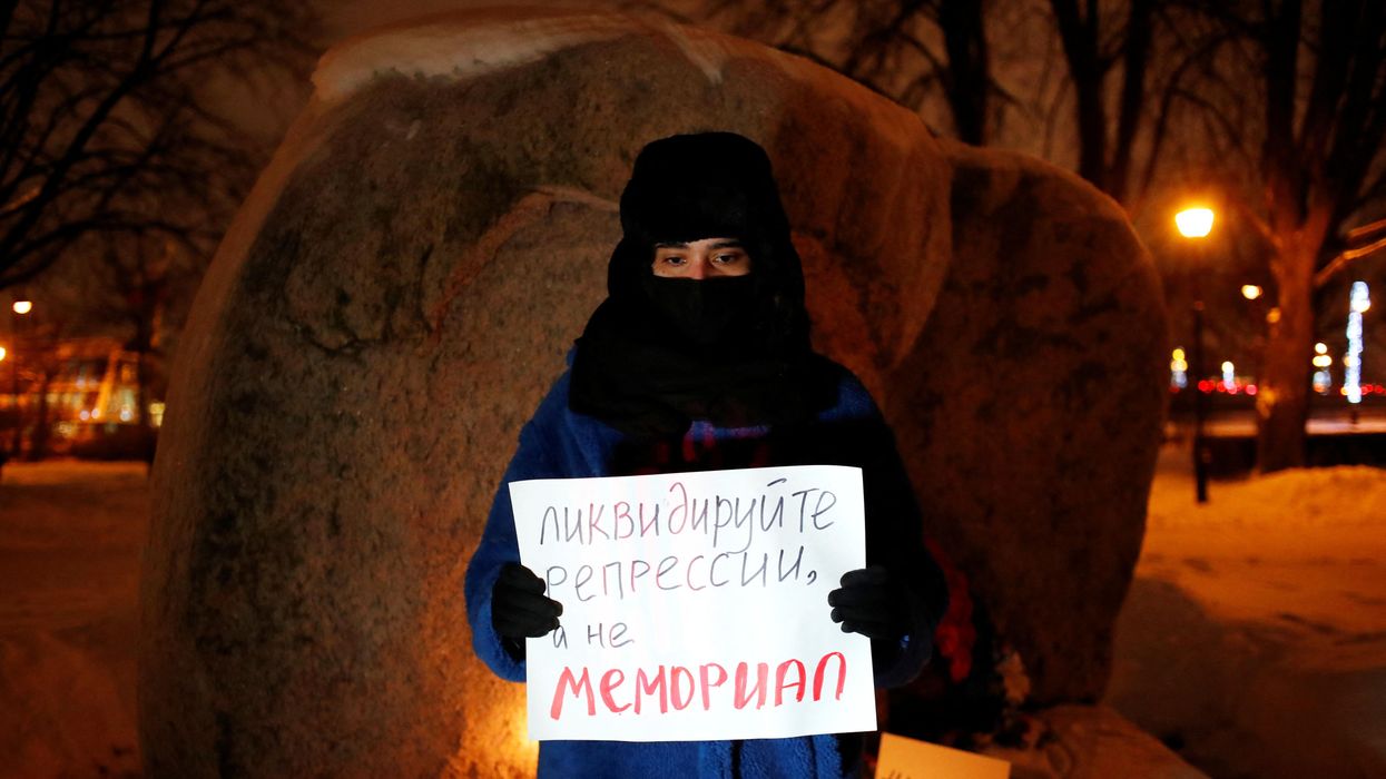 A supporter of the human rights group International Memorial stands with a placard at the Solovetsky Stone memorial after Russia's Supreme Court ruled that International Memorial must be liquidated for breaking the law on foreign agents, in Saint Peterburg, Russia December 28, 2021.