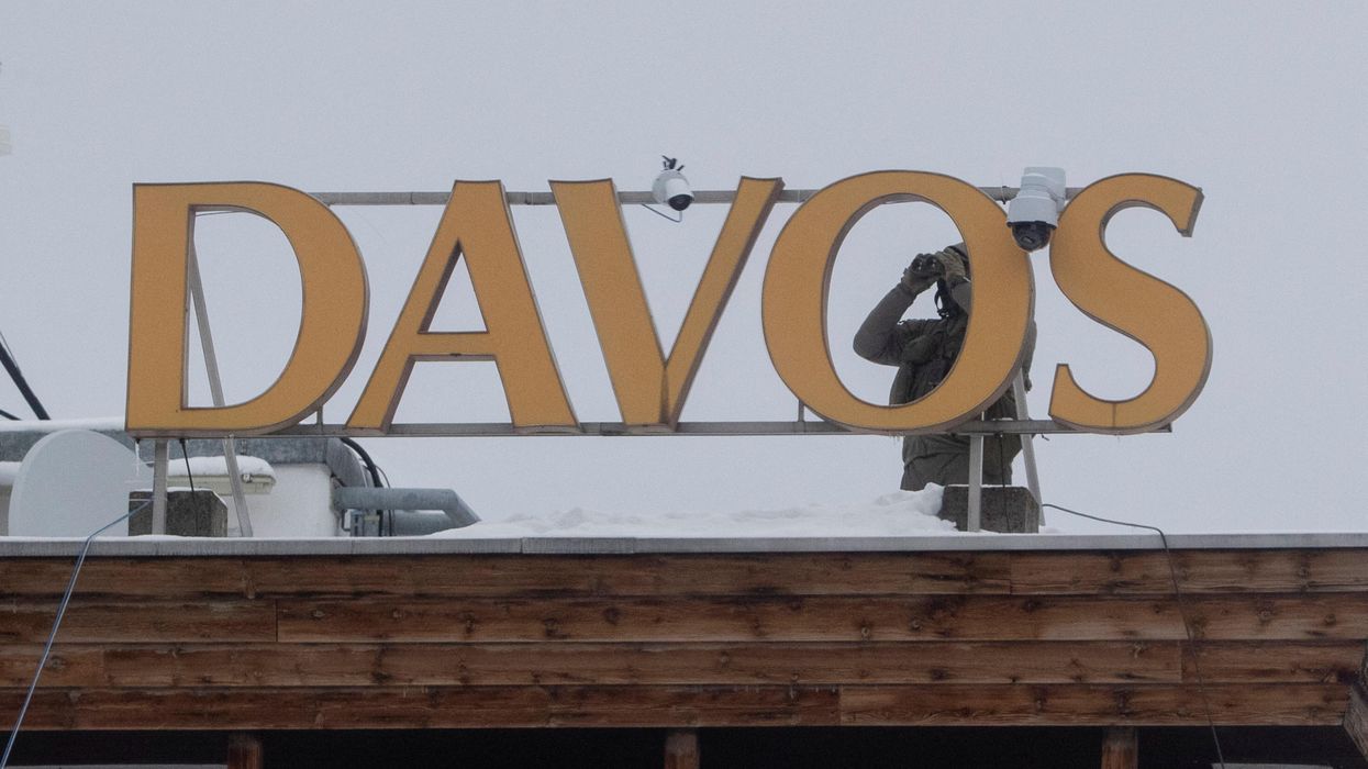 A Swiss police officer looks through a binocular to monitor the area during the World Economic Forum 2023 in Davos, Switzerland.