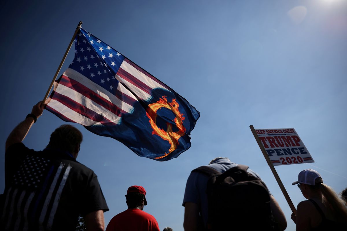 A Trump supporter holds an US flag with a reference to QAnon during a Trump 2020 Labor Day cruise rally in Oregon City, Oregon. Reuters