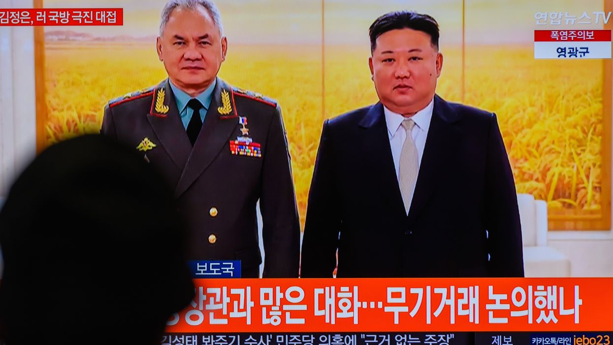 A TV screen shows an image of North Korean leader Kim Jong Un with Russian Defense Minister Sergei Shoigu in Pyongyang.