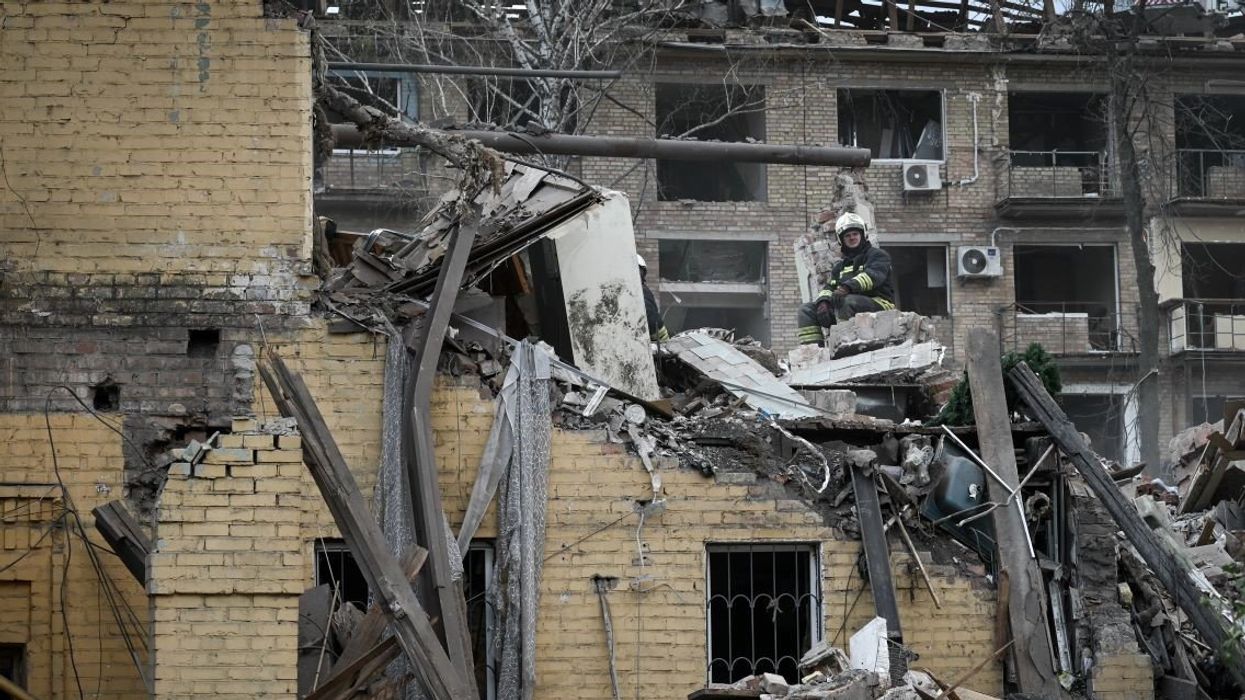 A Ukrainian rescue worker sits atop the rubble of a destroyed residential building during rescue operations, following a Russian missile strike on a residential apartment building block in Kyiv, Ukraine, on April 24, 2025.