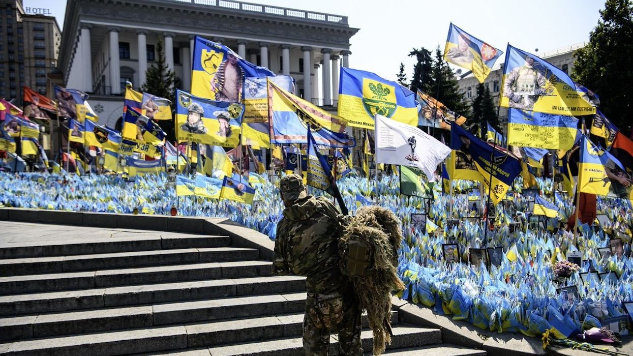 A Ukrainian serviceman commemorates his brothers-in-arms at a makeshift memorial for fallen Ukrainian soldiers on the Day of Remembrance of Ukraine's Defenders, amid Russia's attack on Ukraine, at Independence Square in Kyiv, Ukraine, on August 29, 2024