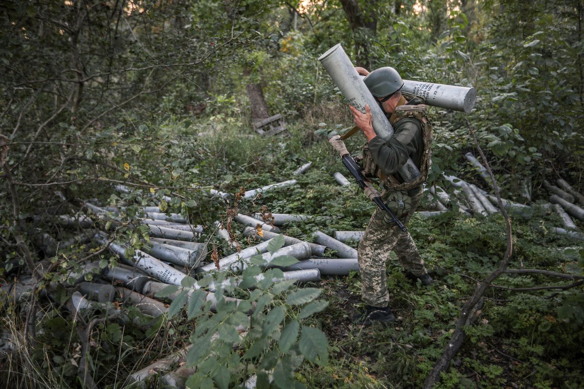 A Ukrainian soldier carries artillery shells to fire in the direction of Bakhmut as the Russia-Ukraine war continues in Donetsk Oblast.