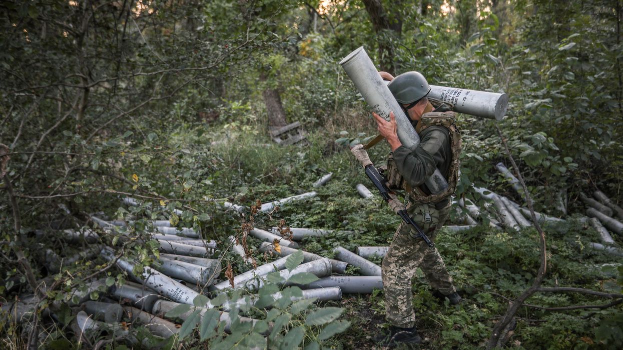 A Ukrainian soldier carries artillery shells to fire in the direction of Bakhmut as the Russia-Ukraine war continues in Donetsk Oblast.