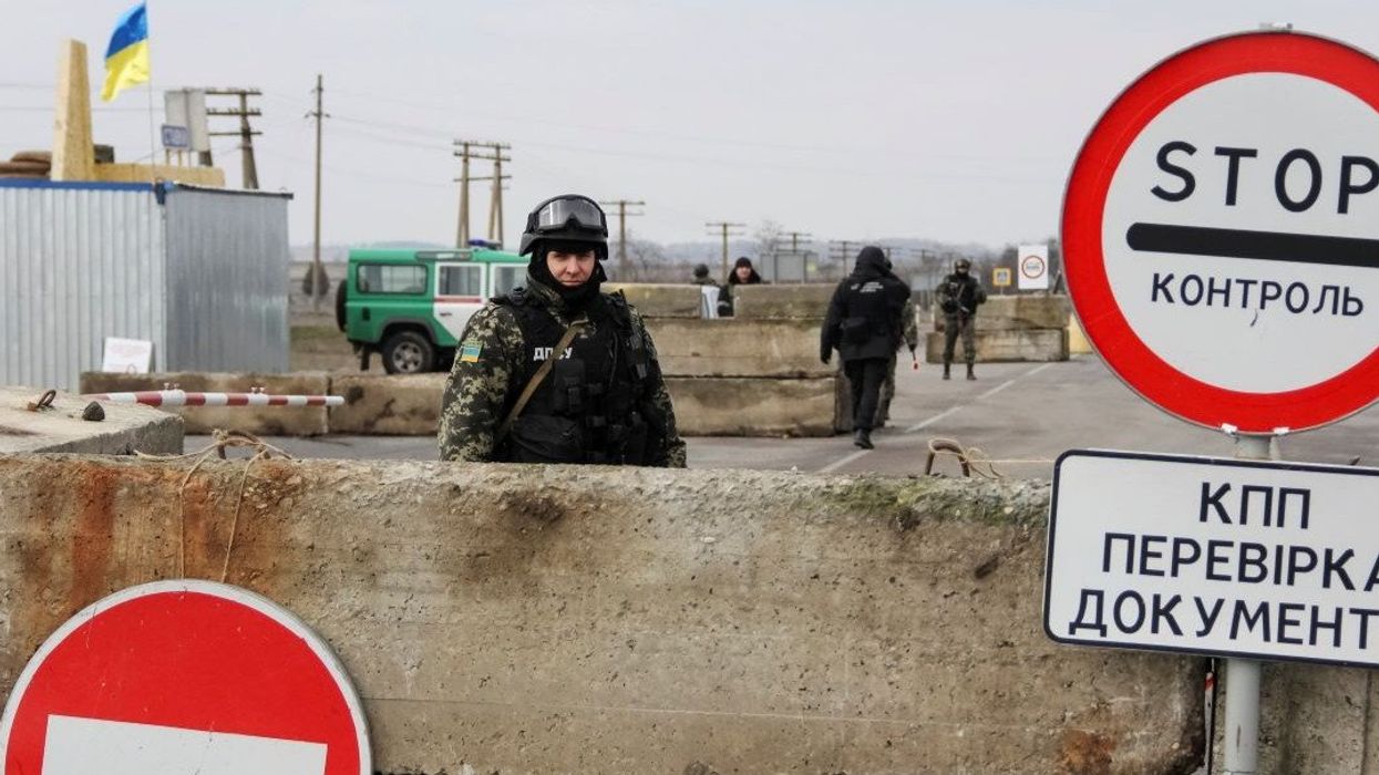 A Ukrainian soldier is seen at a checkpoint at the road near a Crimea region border March 9, 2014. Russian forces tightened their grip on Crimea on Sunday despite a U.S. warning to Moscow that annexing the southern Ukrainian region would close the door to diplomacy in a tense East-West standoff.