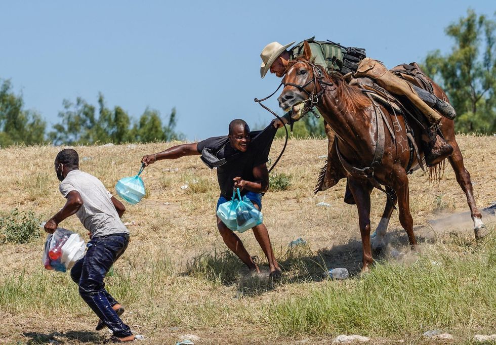 A US Border Patrol agent on horseback tries to stop a Haitian migrant from entering an encampment in Texas on September 19, 2021.