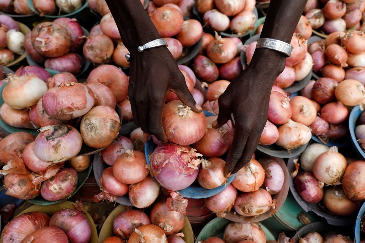 A vendor arranges onions for sale at a market in Lagos, Nigeria.