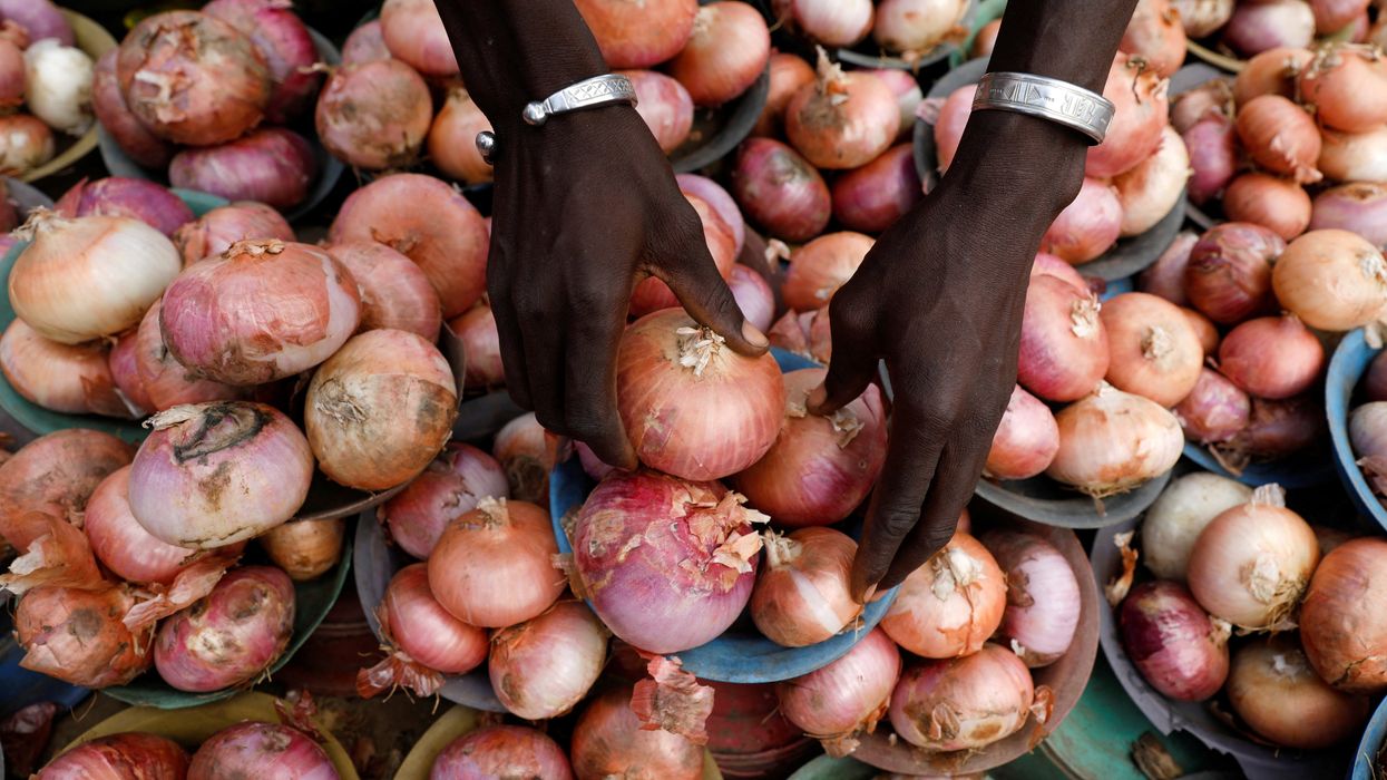 A vendor arranges onions for sale at a market in Lagos, Nigeria.