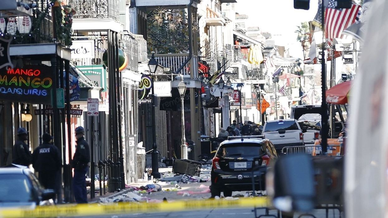 A view down Bourbon Street shows a crashed white pickup truck after an apparent attack during New Year's Eve celebrations in New Orleans.