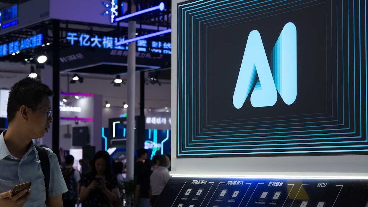 A visitor is walking past an AI sign at the World Artificial Intelligence Conference at the Shanghai World Expo Exhibition Center in Shanghai, China, on July 6, 2024.