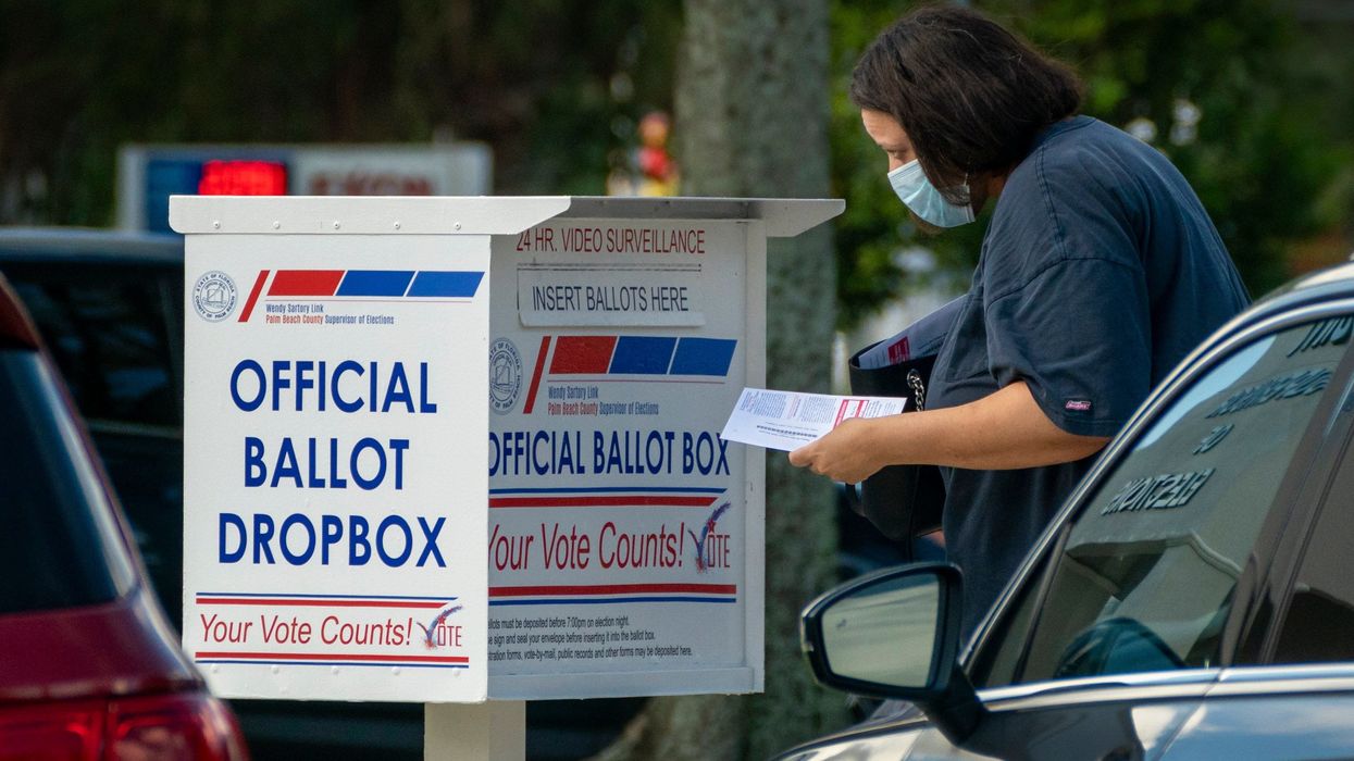 A voter drops off her vote by mail ballot at the Supervisor of Elections office on election day in West Palm Beach, Florida on August 18, 2020.