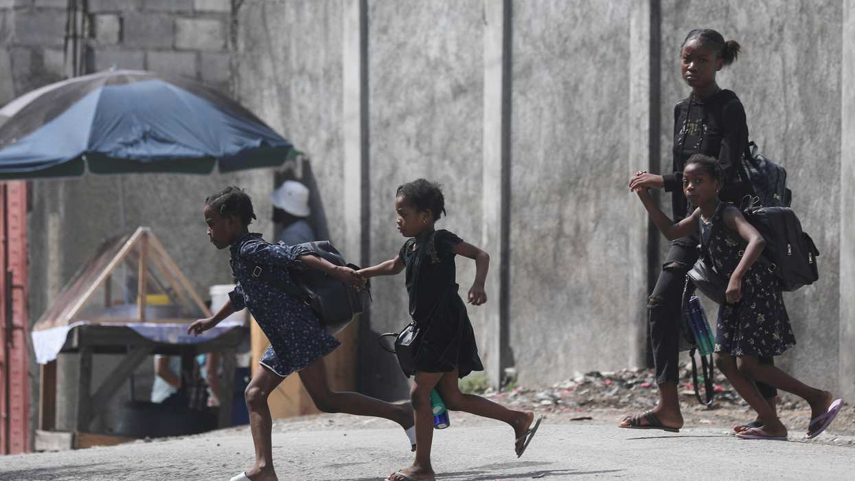 A woman and three children flee their home from gang violence, in Port-au-Prince, Haiti October 20, 2024.