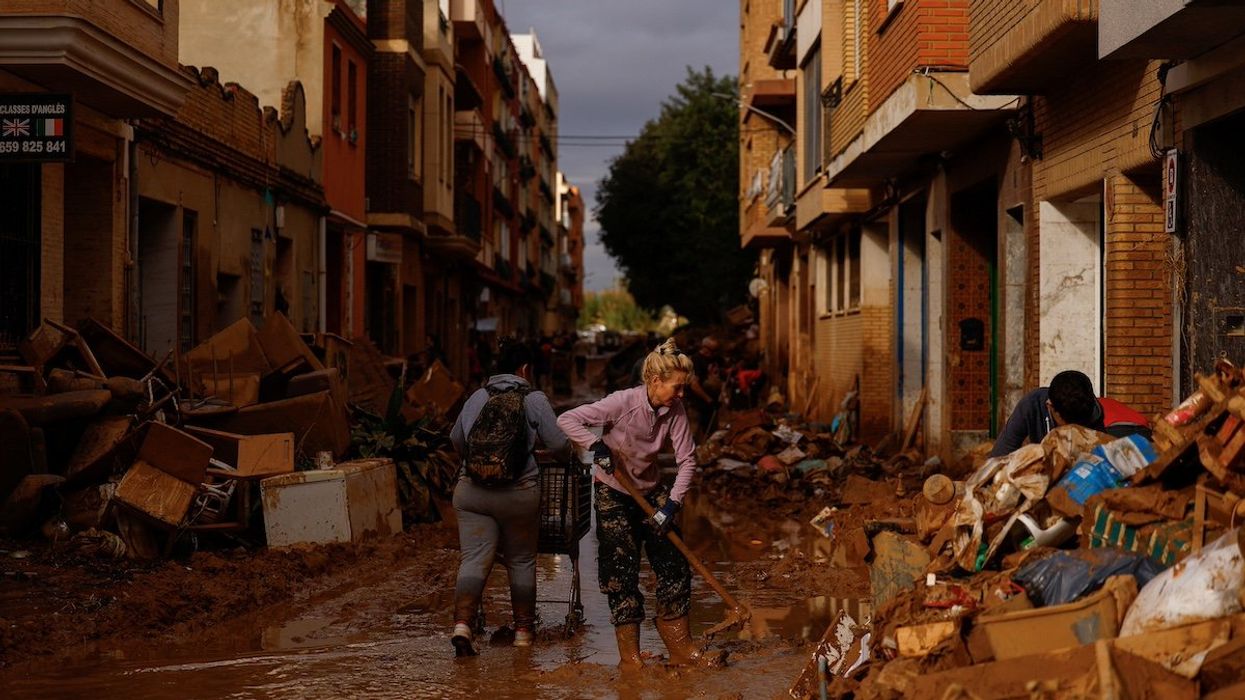 A woman cleans thick mud, in the aftermath of floods caused by heavy rains, in Sedavi, near Valencia, Spain, November 3, 2024.
