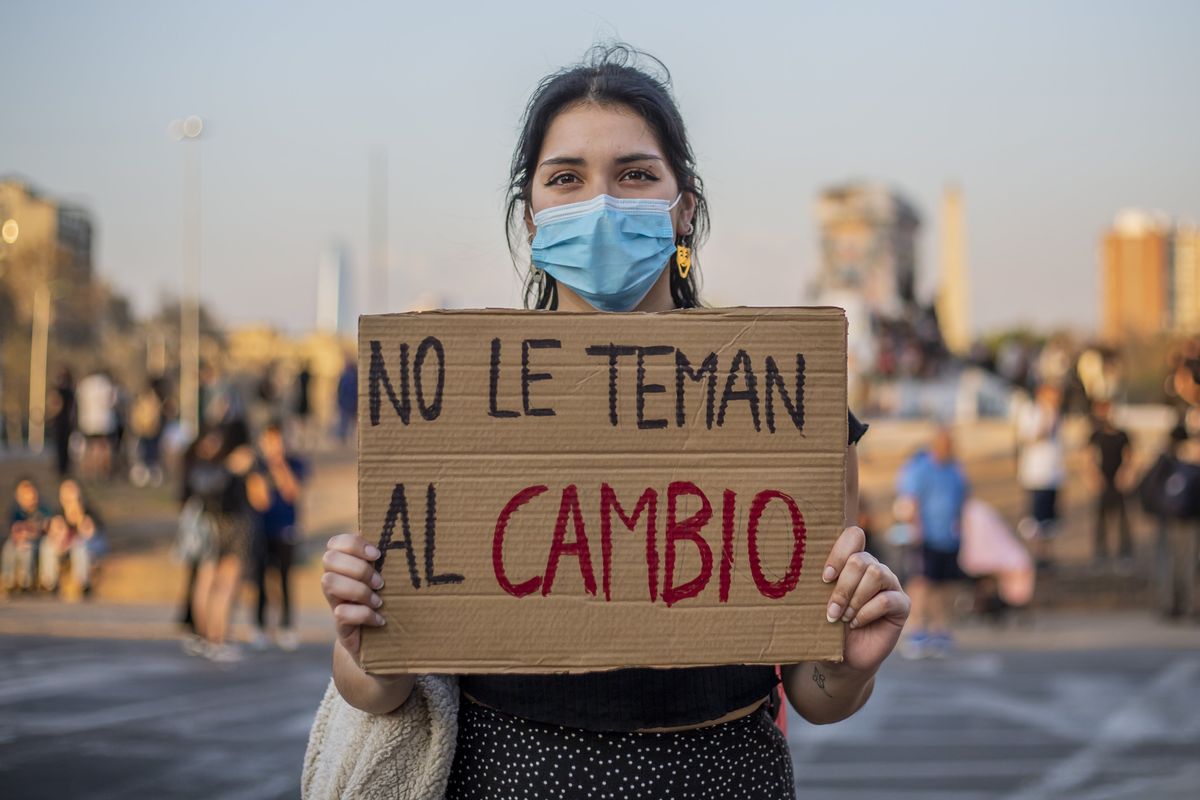 A woman holds a sign with the phrase "Don't be afraid of change" following the constitutional referendum in Santiago de Chile.