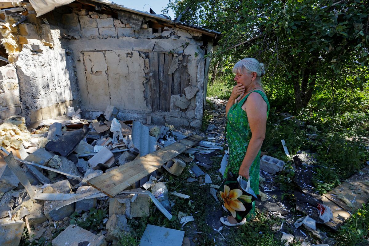 ​A woman outside the damaged house of her son, who was killed the day before by shelling in Donetsk, Russian-controlled Ukraine. 