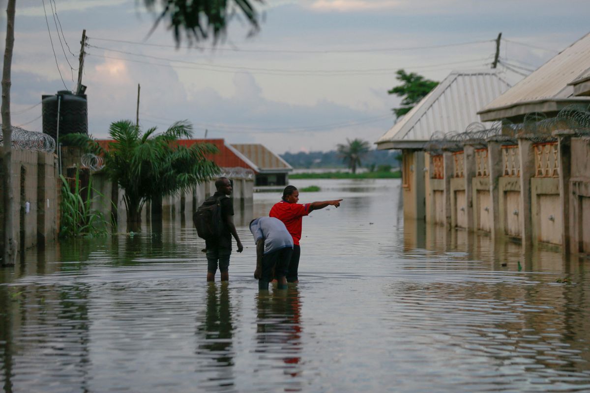 A woman points at the direction of her flooded home close to the shore of River Benue in Makurdi, Nigeria.