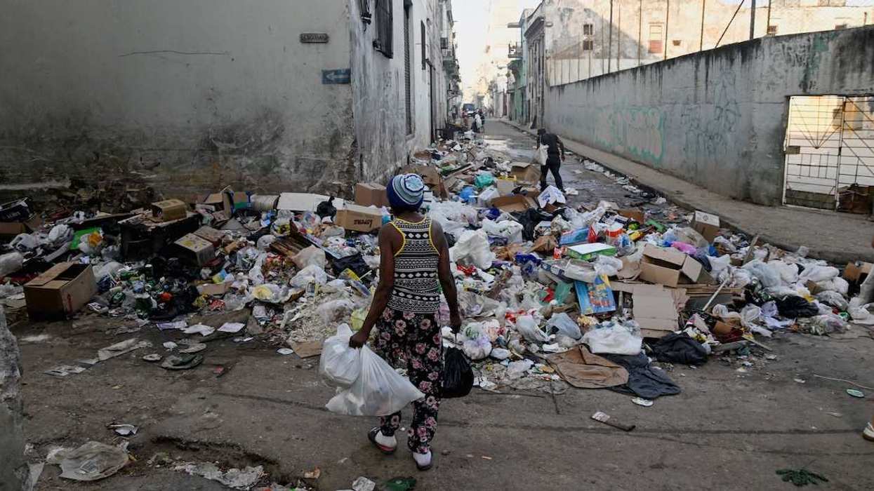 A woman prepares to throw trash on a street in downtown Havana, Cuba, February 16, 2026. 