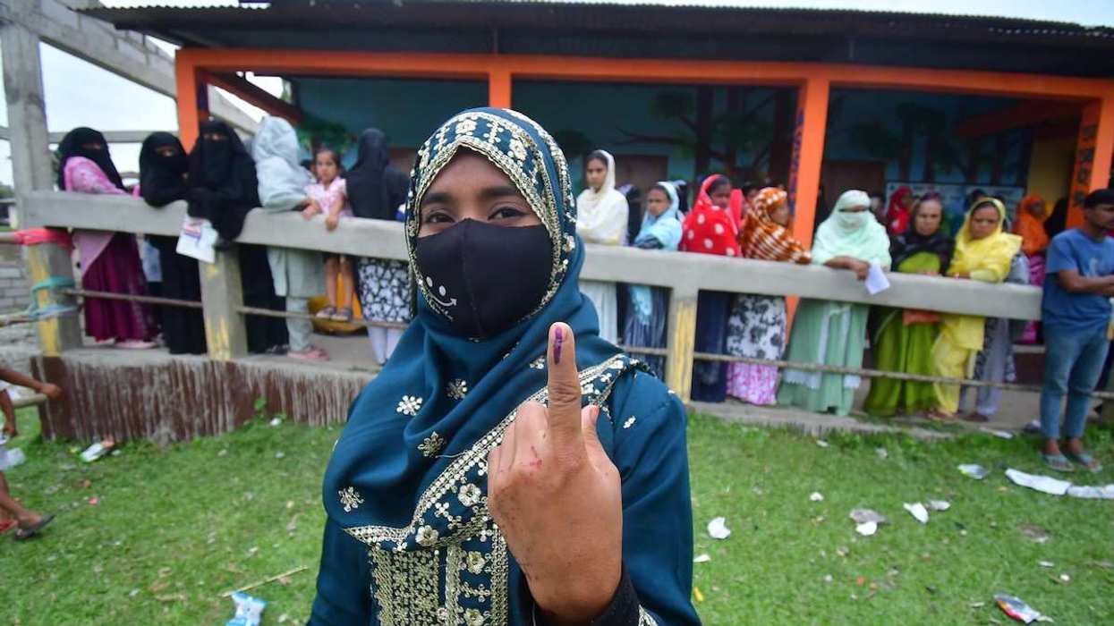 A woman shows her ink-marked finger after casting her ballot at a polling station during the Assam Legislative Assembly election in Nagaon District, Assam, India, on April 9, 2026.