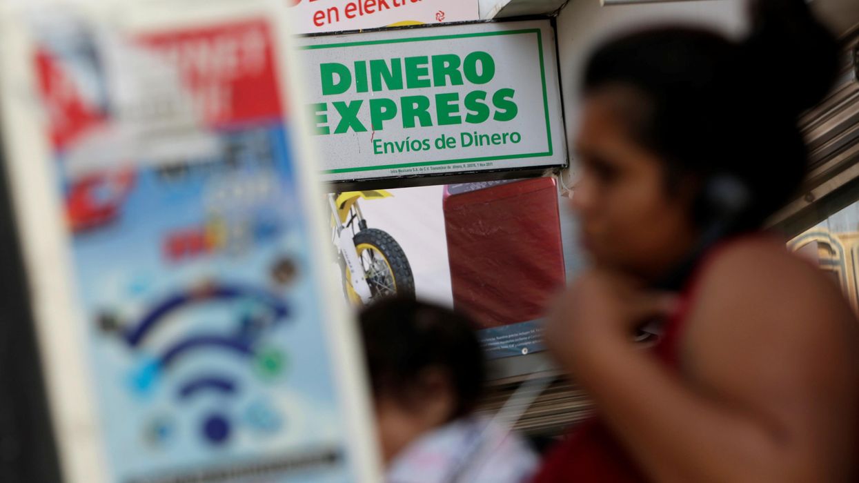 A woman speaks on the phone outside a money exchange office in Ciudad Juarez, Mexico.