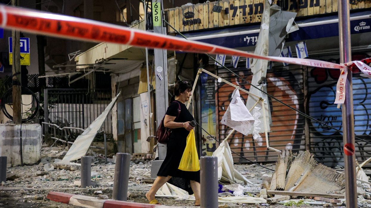 A woman walks past the site where a rocket launched from the Gaza Strip landed in Tel Aviv, Israel, on Oct. 7, 2023.