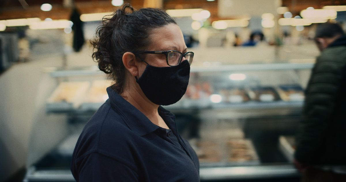 A woman wearing a face mask in a fish market 