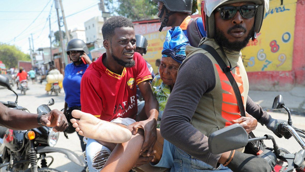 ​A woman with a gunshot wound is transported by two men on a motorcycle as Haiti remains in state of emergency due to the violence, in Port-au-Prince, Haiti March 9, 2024. 