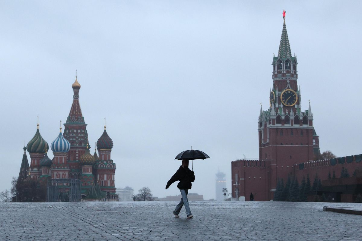 A woman with an umbrella crosses the deserted Red Square. A recent surge in COVID-19 cases in Russia has prompted the Moscow authorities to declare non-working days with pay from October 28 to November 7. 