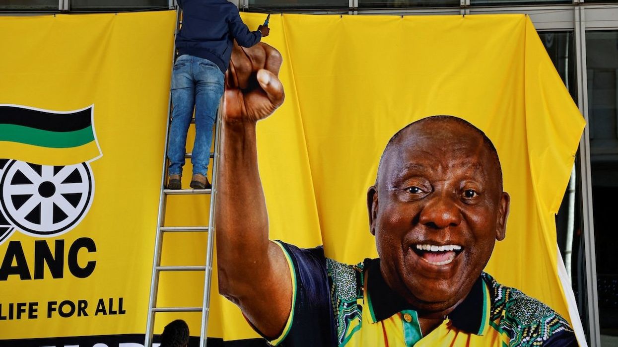 A worker removes a campaign banner of South African president Cyril Ramaphosa after an African National Congress event ahead of the upcoming elections in Sandton, Johannesburg, South Africa, on May 25, 2024. 