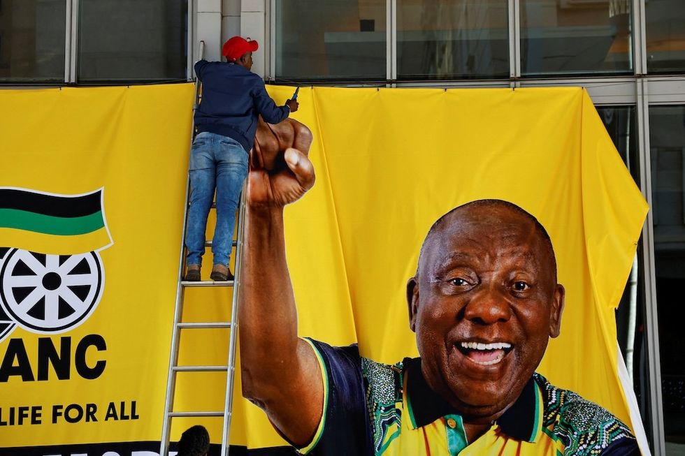A worker removes a campaign banner of South African president Cyril Ramaphosa after an African National Congress event ahead of the upcoming elections in Sandton, Johannesburg, South Africa, on May 25, 2024. 