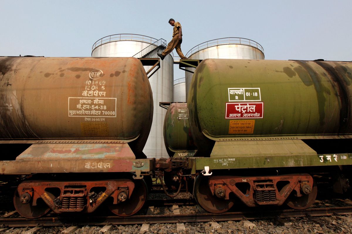 A worker walks atop a oil tanker wagon