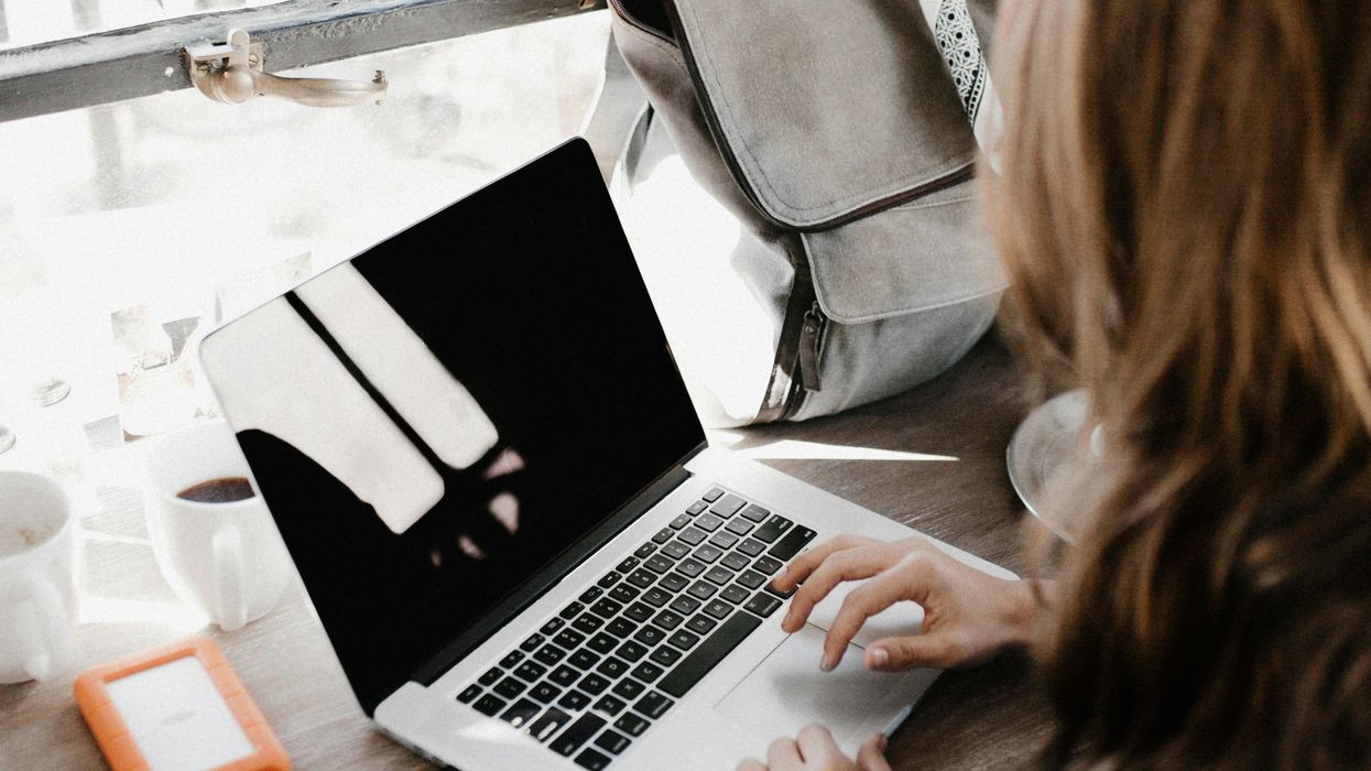 A young anonymous woman working on a laptop.