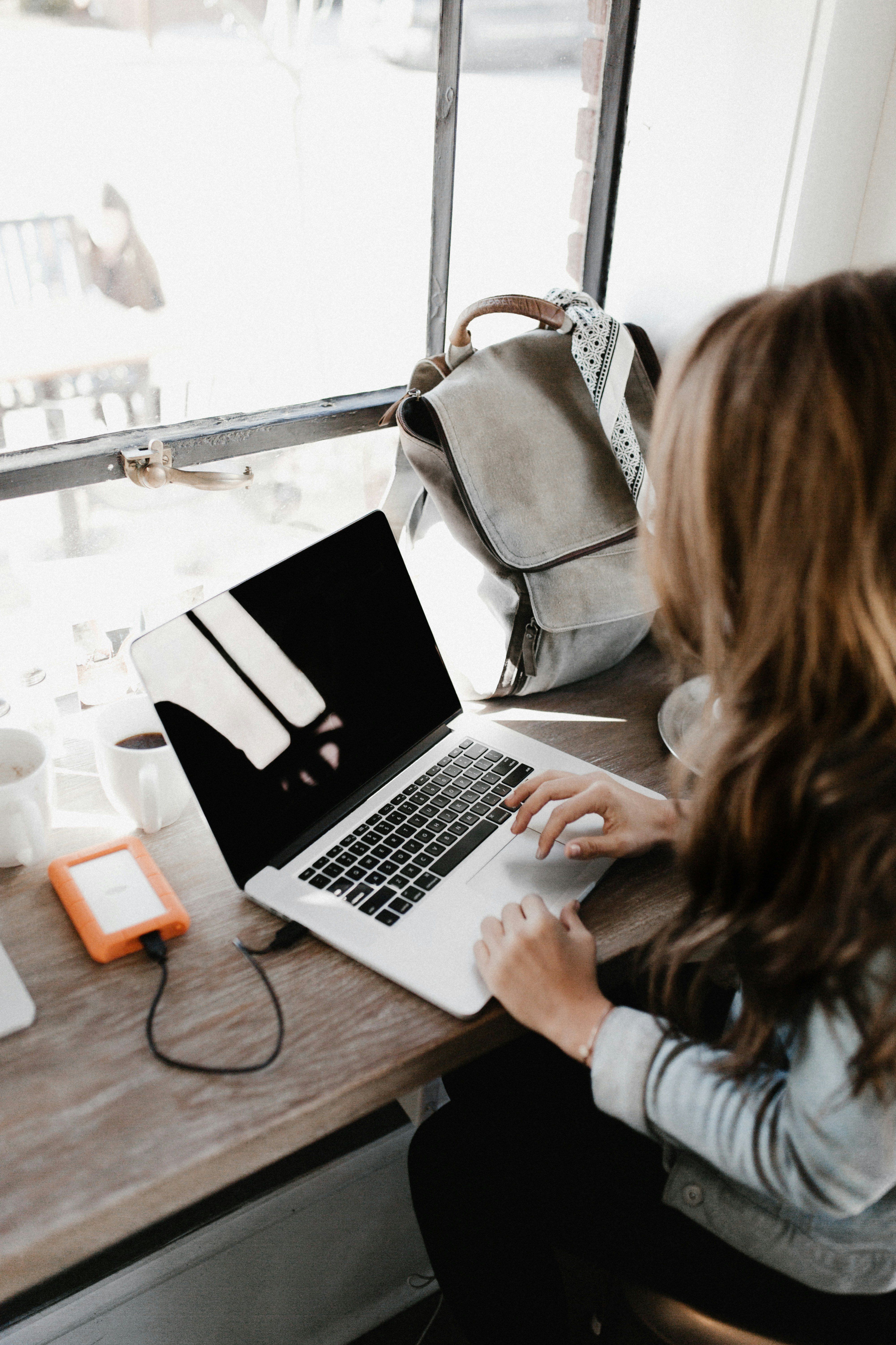 A young anonymous woman working on a laptop.
