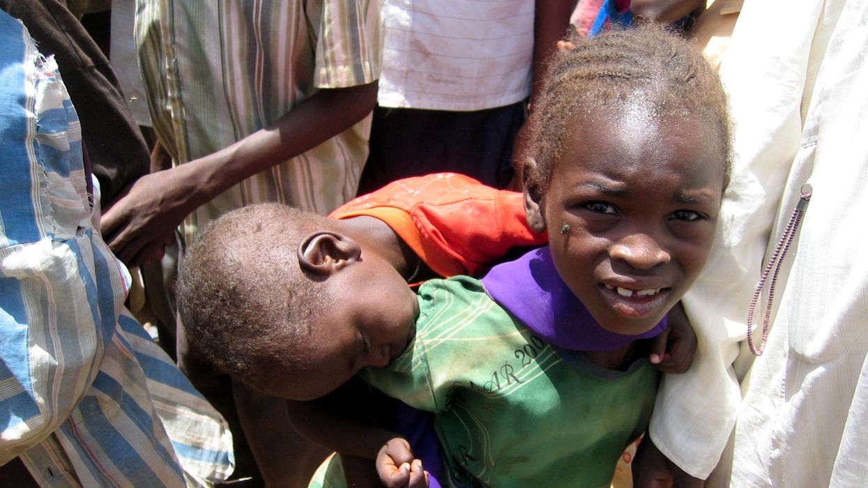 A young Darfuri girl carries her sleeping brother at Zam Zam camp in Sudan's North Darfur state