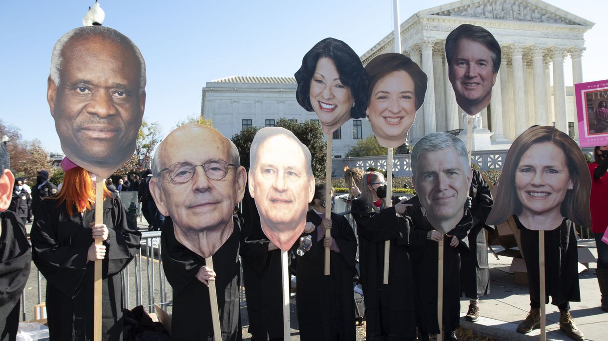 Activists carry caricatures of Supreme Court justices Rep. Marjorie Taylor-Greene peaks with people outside of the Supreme Court on Tuesday, December 1st, as the justices began hearing oral arguments in a case that challenges abortion rights in the United States.