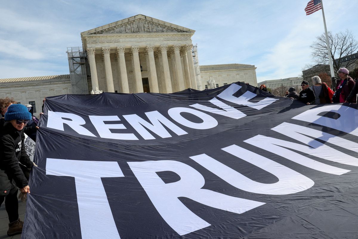Activists hold up a banner following arguments in former U.S. President Donald Trump's appeal of a lower court's ruling disqualifying him from the Colorado presidential primary ballot, in Washington, U.S., February 8, 2024. 