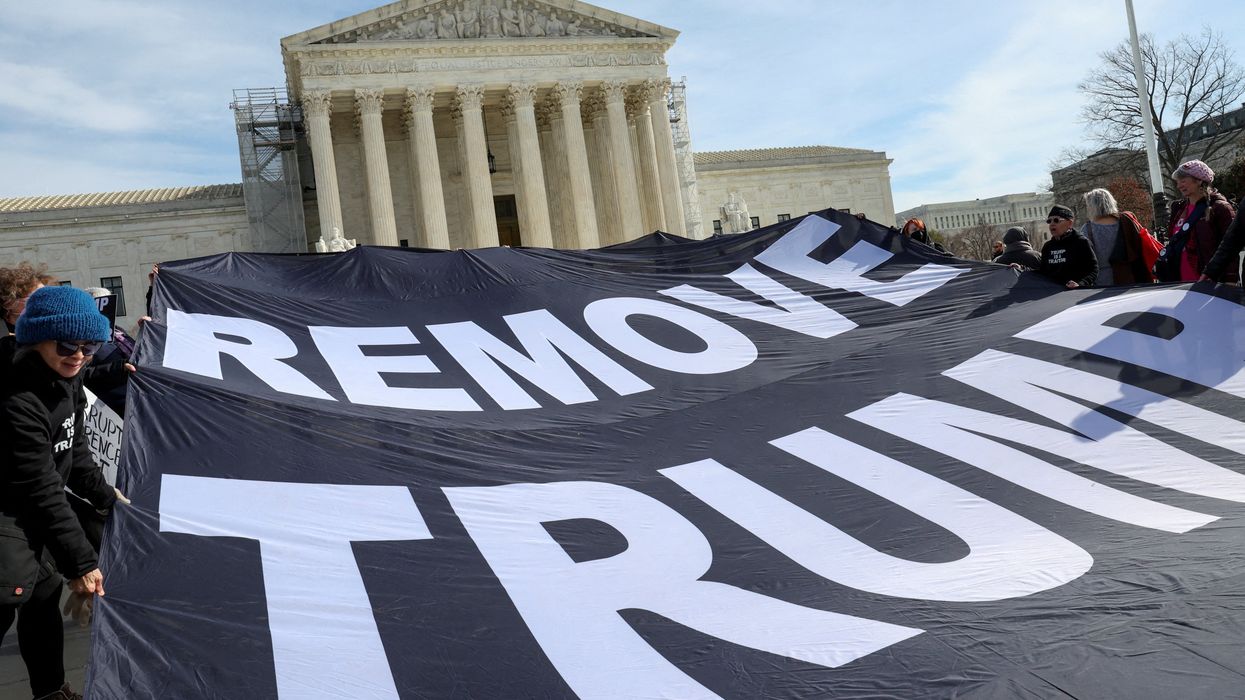 Activists hold up a banner following arguments in former U.S. President Donald Trump's appeal of a lower court's ruling disqualifying him from the Colorado presidential primary ballot, in Washington, U.S., February 8, 2024.