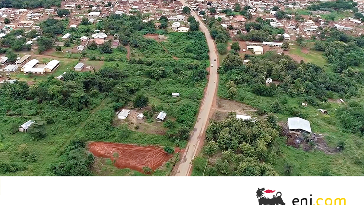 Aerial view of a rural area with trees and a winding road in Ghana.
