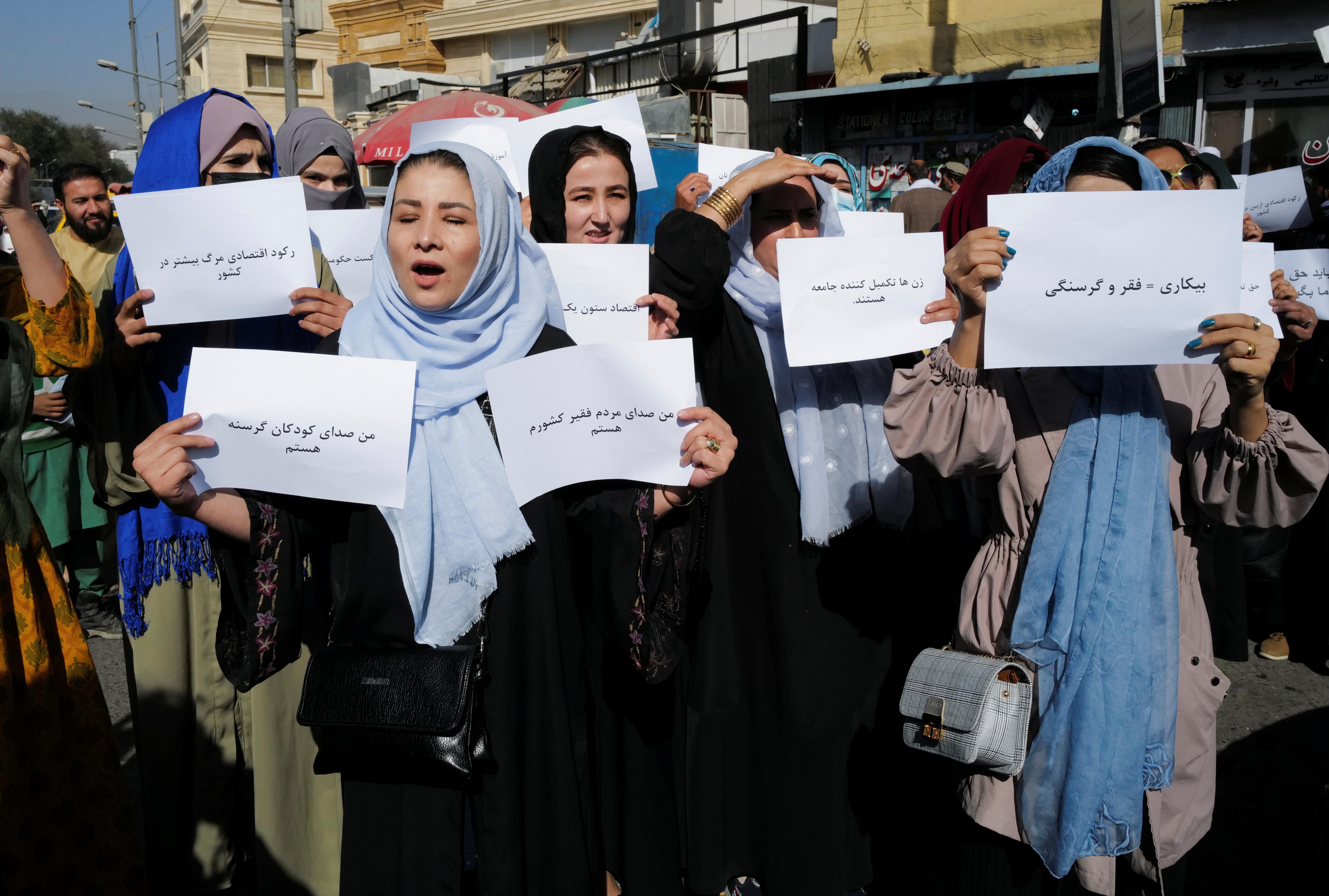 Afghan women hold signs as they gather for a women's rights protest march in central Kabul, Afghanistan October 21, 2021. 