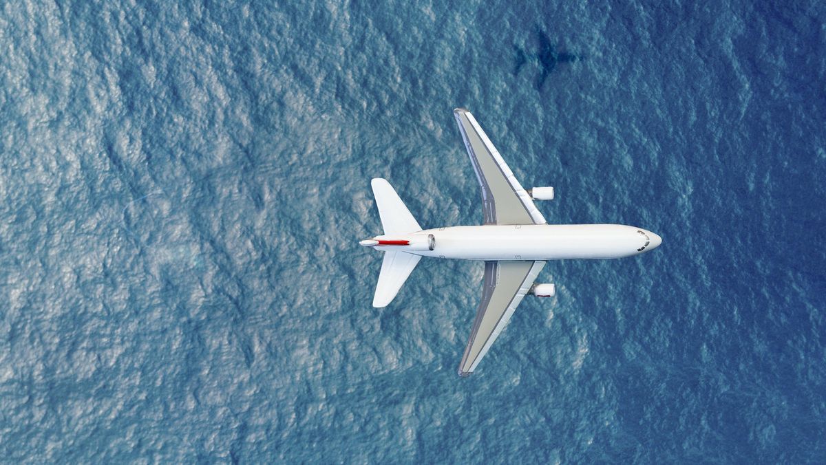 Airplane flying above water.
