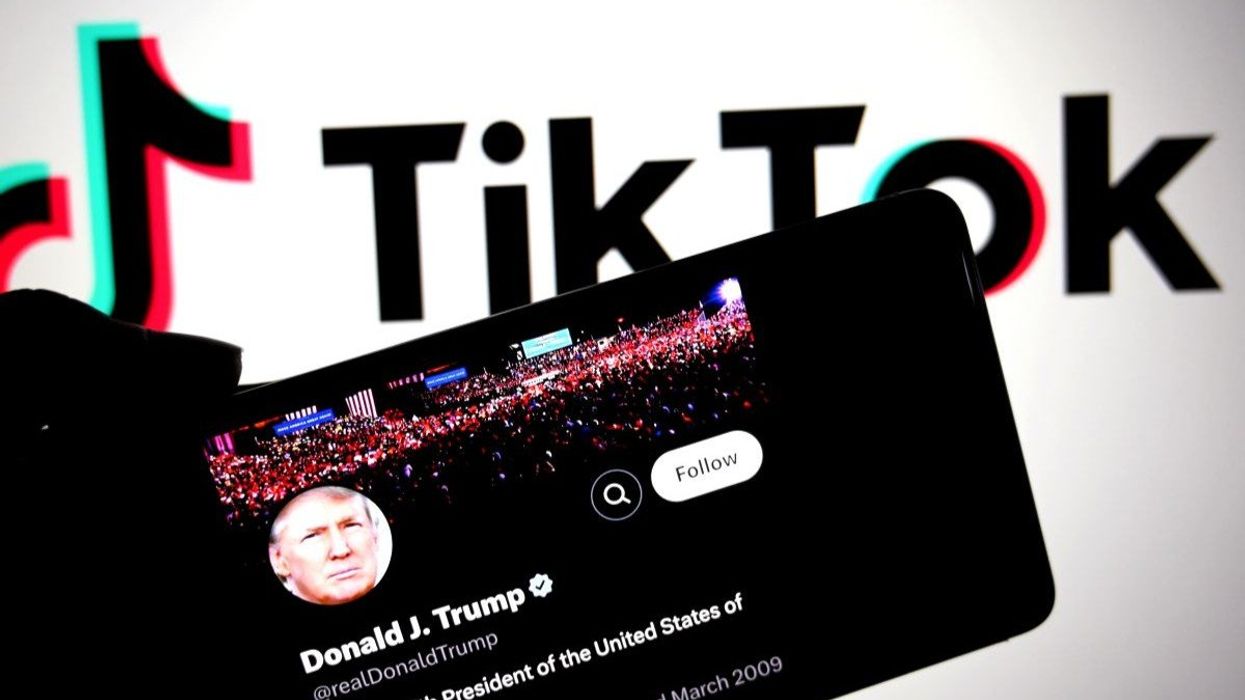 American President Donald Trump's X Page is seen displayed on a smartphone with a Tiktok logo in the background.