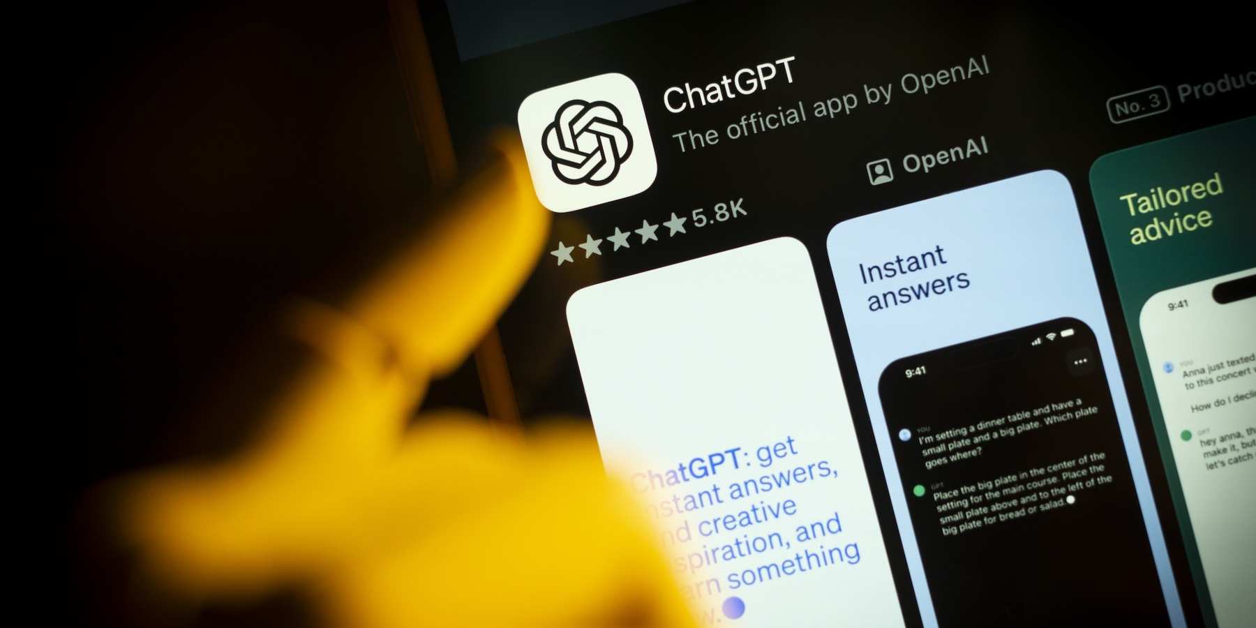 An artificial hand is seen pointing a finger at a mobile phone screen displaying the Apple App Store with the Chat GPT app in this photo illustration.