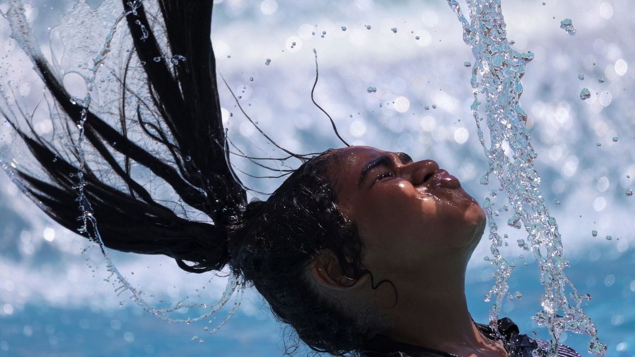 An Egyptian girl whips her wet hair while cooling off in the water amid a heatwave in Hurghada, Egypt.