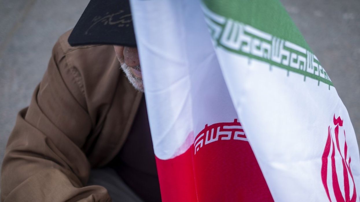An elderly man holds an Iranian flag during an anti-U.S. and anti-Israel rally marking the anniversary of the U.S. embassy occupation outside the former U.S. embassy in downtown Tehran, Iran, on November 3, 2024, two days before the U.S. Presidential elections.