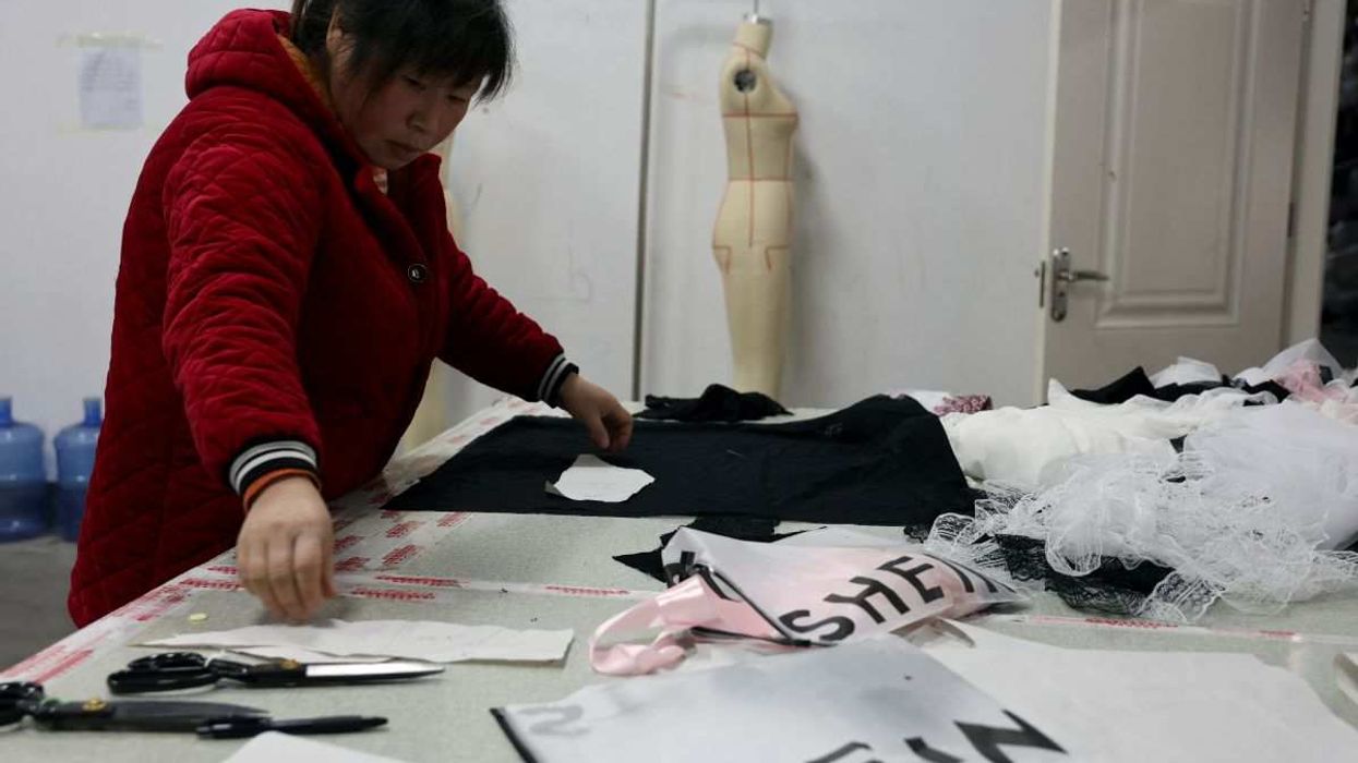 An employee prepares to cut a fabric next to Shein packaging at the Midnight Charm Garment lingerie factory in Guanyun county of Lianyungang, Jiangsu province, China November 25, 2024.